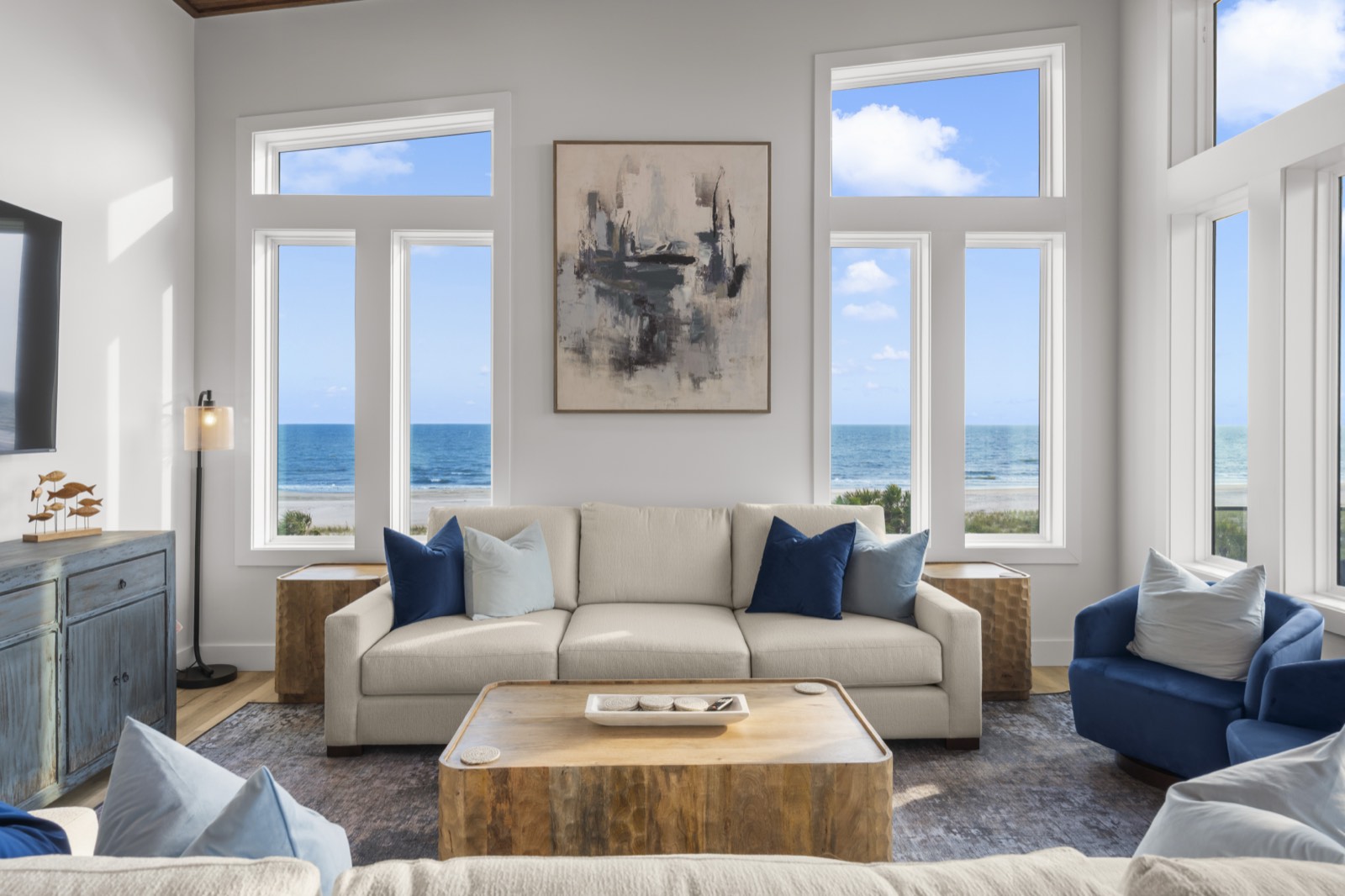 Oceanfront living room with tall windows framing the Gulf horizon