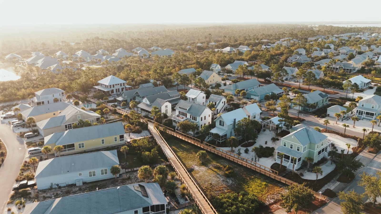 Aerial view over rooftops of a coastal neighborhood at golden hour